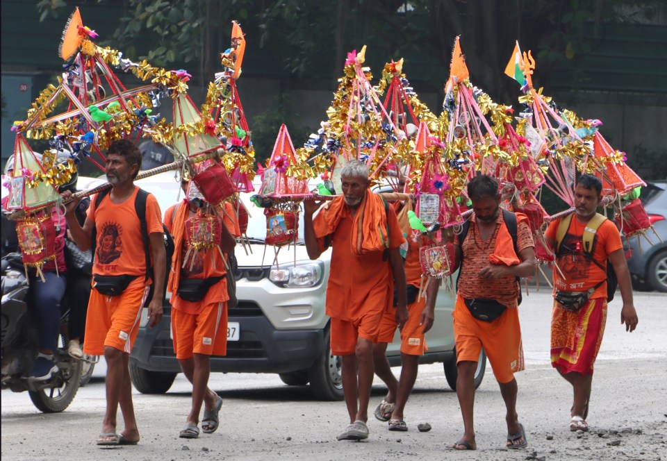 New Delhi: Lord Shiva devotees or 'Kanwariyas' walk during the 'Kanwar Yatra' carrying holy water from the Ganga river